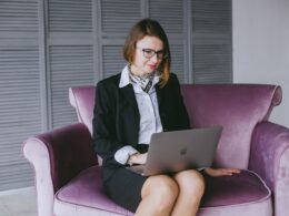 a woman sitting on a couch using a laptop computer