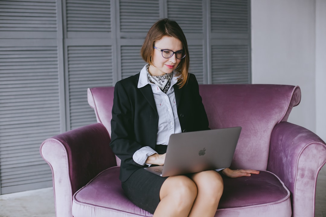a woman sitting on a couch using a laptop computer