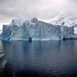 white iceberg near white mountains