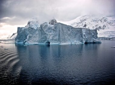white iceberg near white mountains