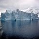 white iceberg near white mountains
