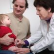 a doctor examines a baby's chest with a stethoscope