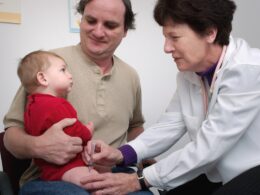 a doctor examines a baby's chest with a stethoscope