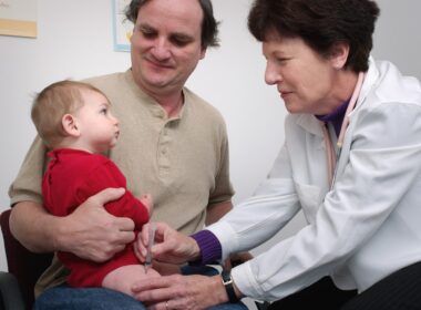 a doctor examines a baby's chest with a stethoscope