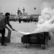 a man pulling a cart with a lot of smoke coming out of it