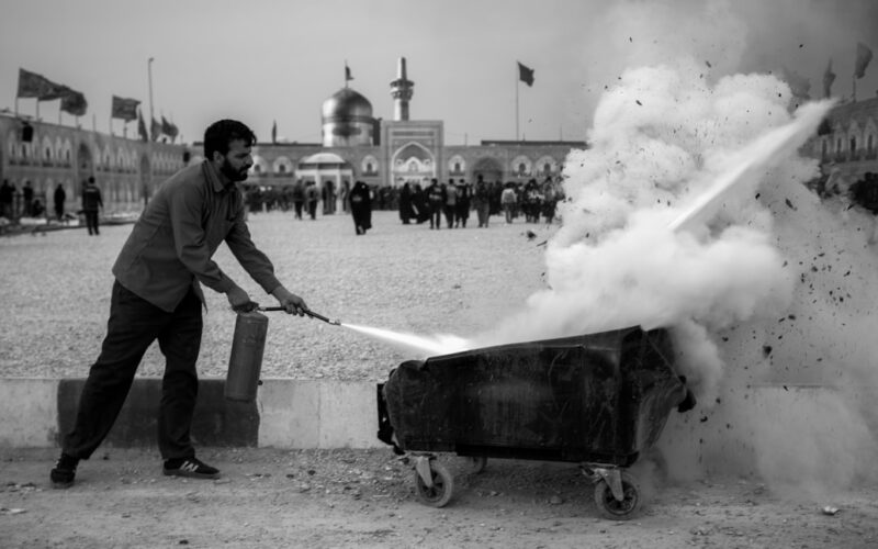 a man pulling a cart with a lot of smoke coming out of it