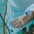 a person in a hospital bed with an iv