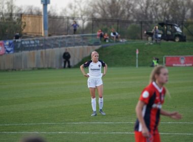 two women are playing soccer on a field