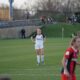 two women are playing soccer on a field