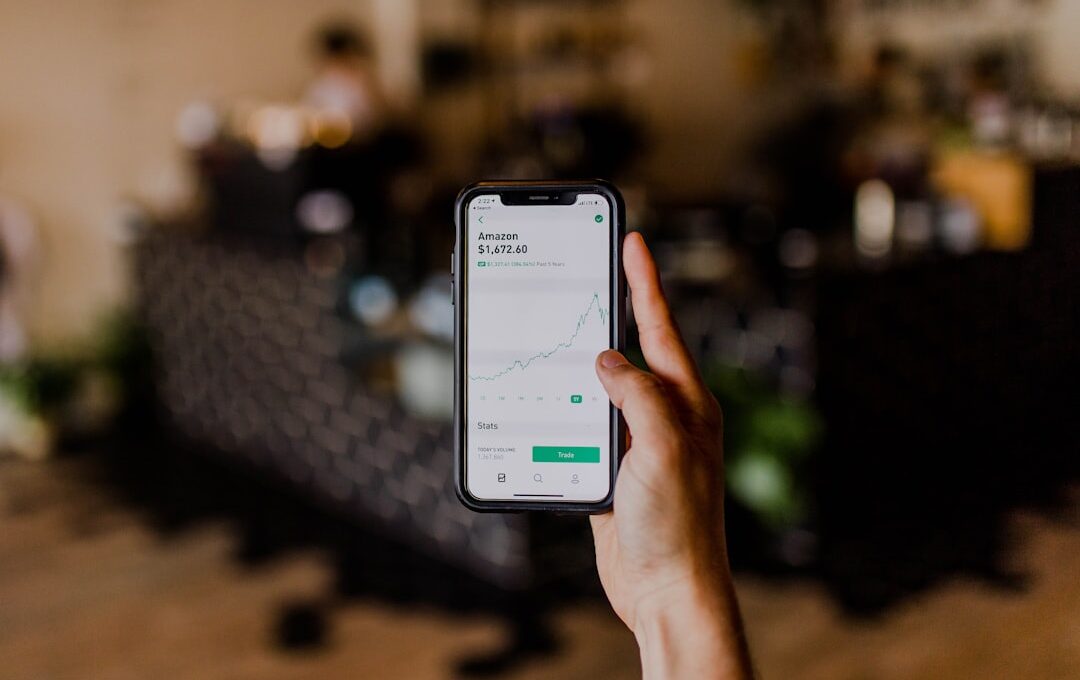 person holding black iPhone displaying stock exchange