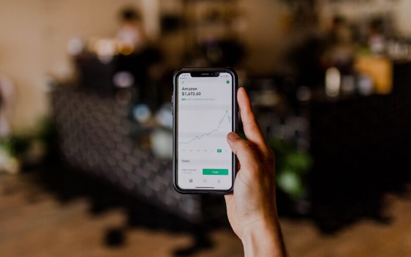 person holding black iPhone displaying stock exchange