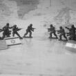 Toy soldiers in formation with flags on world map