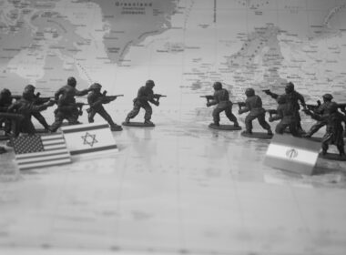 Toy soldiers in formation with flags on world map