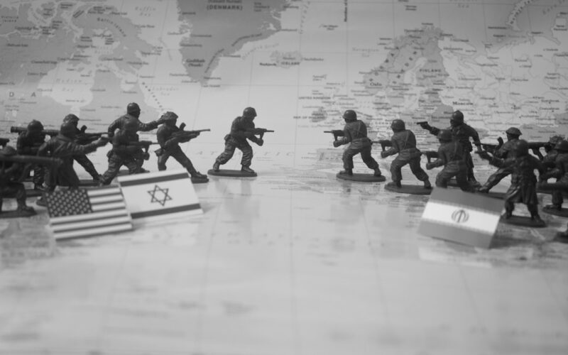 Toy soldiers in formation with flags on world map