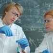 Scientists in lab coats working with test tubes