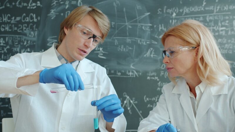Scientists in lab coats working with test tubes