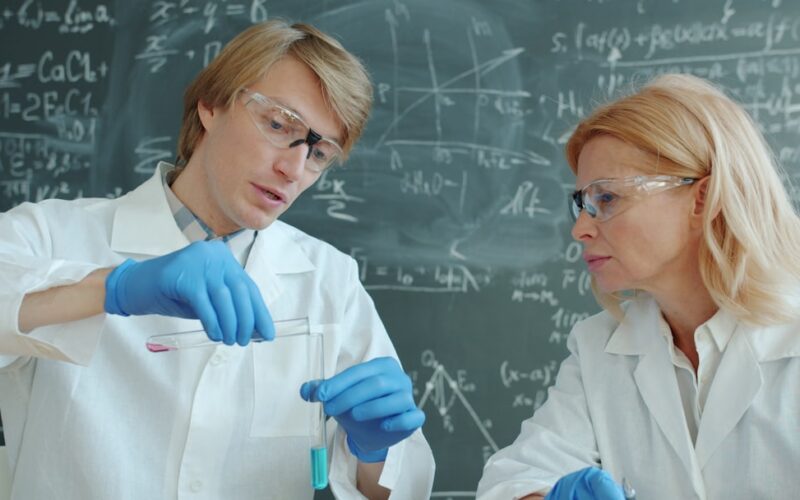 Scientists in lab coats working with test tubes