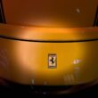 A yellow ferrari car's rear with the iconic emblem