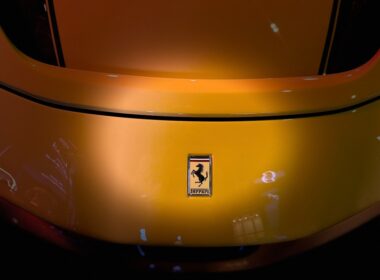 A yellow ferrari car's rear with the iconic emblem