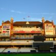 Ornate cricket stadium building with empty seats.