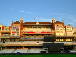 Ornate cricket stadium building with empty seats.