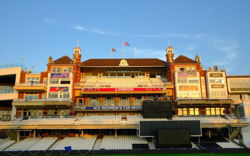 Ornate cricket stadium building with empty seats.