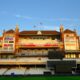 Ornate cricket stadium building with empty seats.