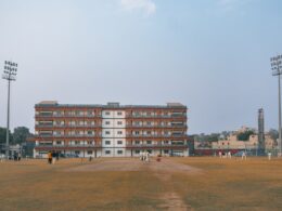 Cricket field with a large brick building and stadium lights