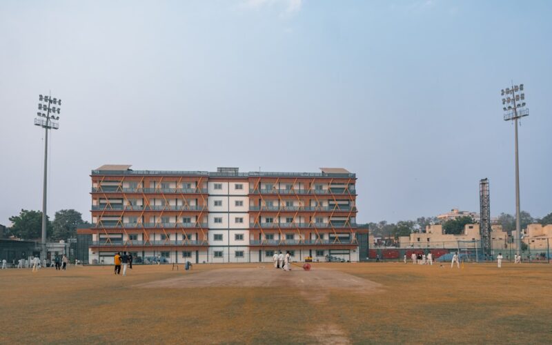 Cricket field with a large brick building and stadium lights