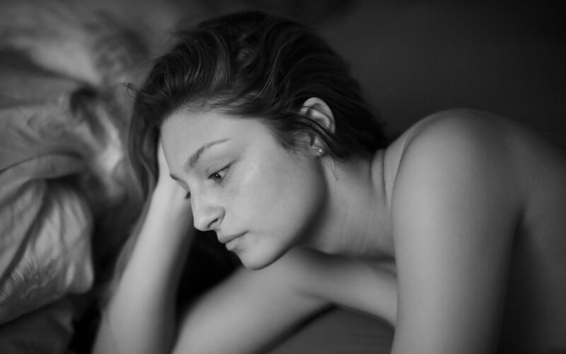 topless woman lying on bed