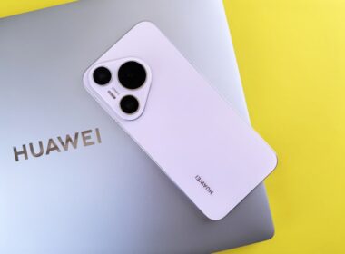 A white cell phone sitting on top of a laptop computer