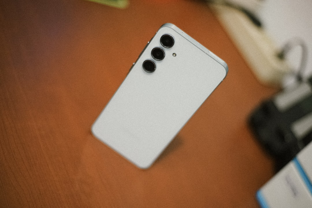 White smartphone with three cameras on desk