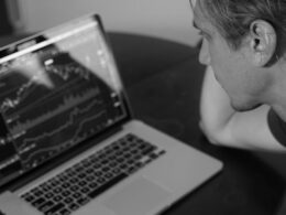 grayscale photo of man looking at macbook pro