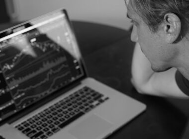 grayscale photo of man looking at macbook pro