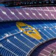 a sports arena with a field and seating