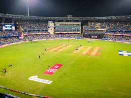 A cricket match is in progress at a stadium