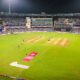 A cricket match is in progress at a stadium