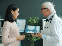 Doctor shows patient medical scan on tablet