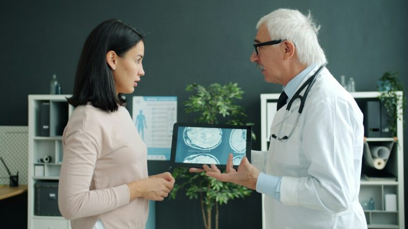 Doctor shows patient medical scan on tablet