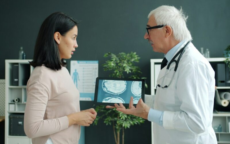 Doctor shows patient medical scan on tablet
