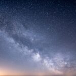 a starry night sky with a few clouds
