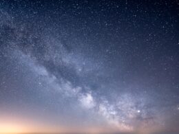 a starry night sky with a few clouds
