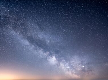 a starry night sky with a few clouds