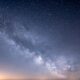 a starry night sky with a few clouds