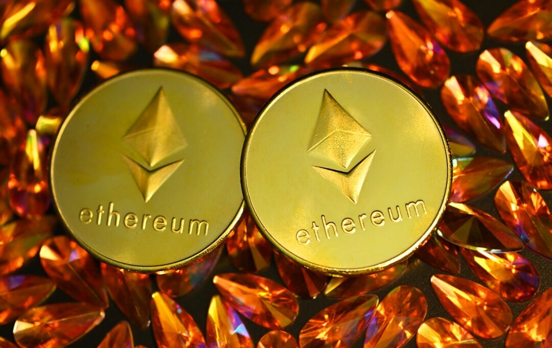 two gold ethereum tokens sitting on top of a pile of crystals