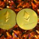 two gold ethereum tokens sitting on top of a pile of crystals