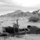 an old car sitting in the middle of a desert