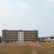Cricket field with stadium lights and building