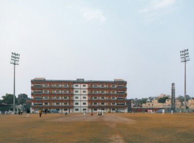 Cricket field with stadium lights and building