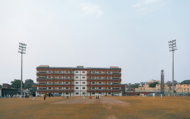 Cricket field with stadium lights and building